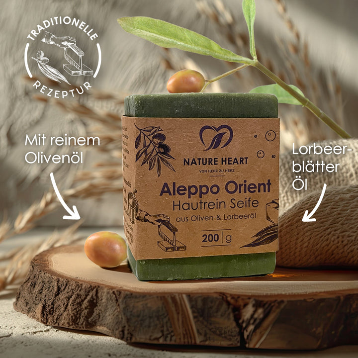 Aleppo Orient Hautrein Seife 200 g auf einer Holzscheibe mit den Hinweisen reines Olivenöl, Lorbeerblätter-Öl und traditionelle Rezeptur
