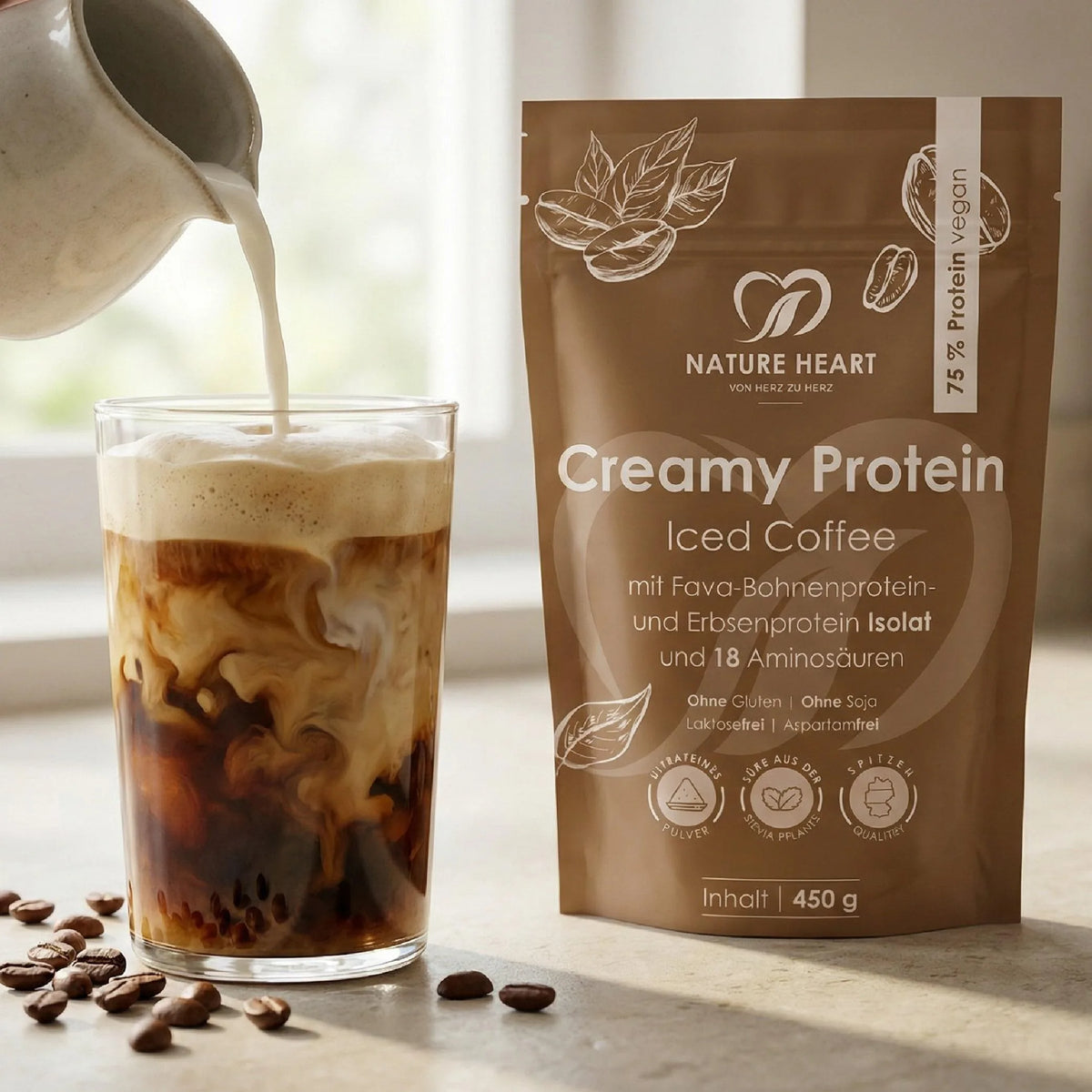 Creamy Protein Iced Coffee im 450-g-Beutel neben einem Glas Iced Coffee, in das ein Drink gegossen wird, davor Kaffeebohnen