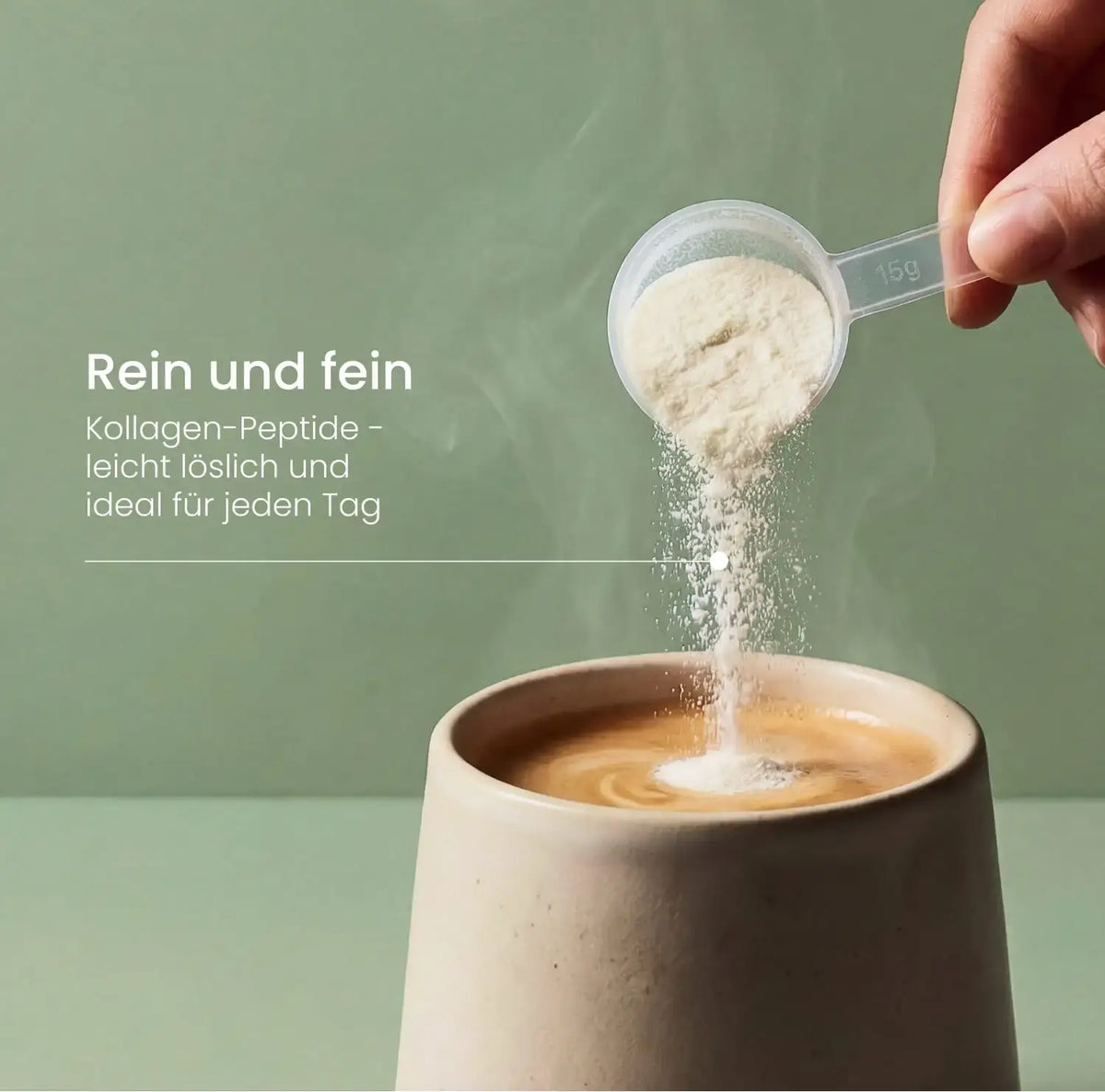 Kollagen-Peptide rieseln aus einem 15-g-Messlöffel in einen dampfenden Becher Kaffee, Hinweis: rein, fein und leicht löslich