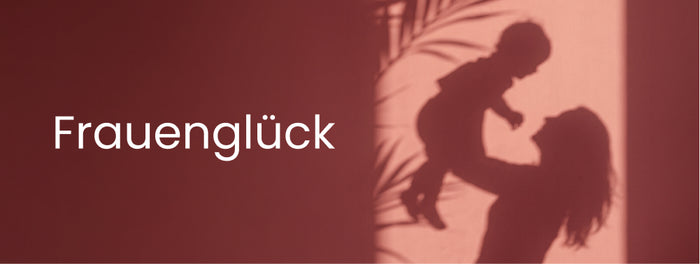 Banner mit der Aufschrift Frauenglück auf rötlichem Hintergrund, rechts der Schatten einer Person, die ein kleines Kind hochhebt.