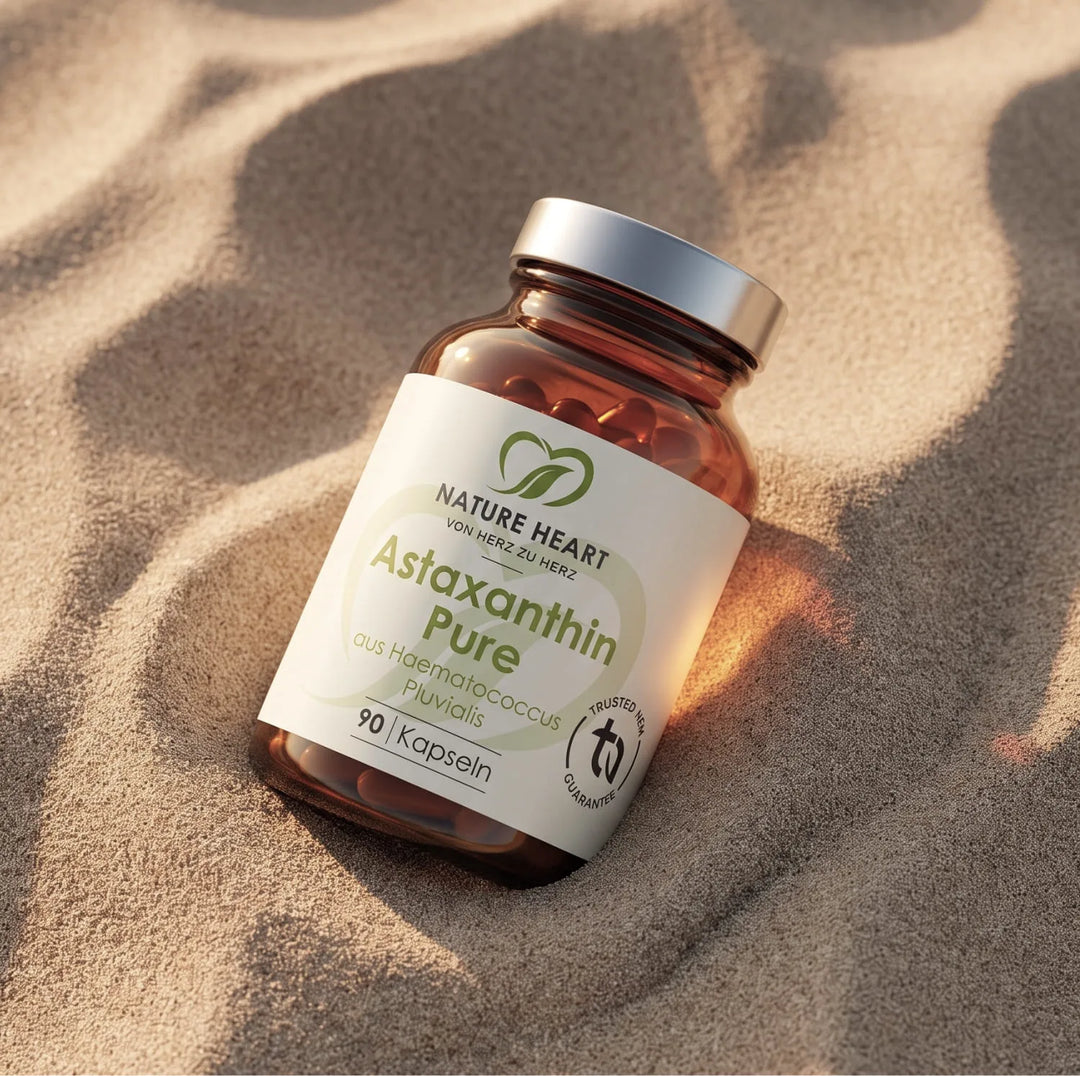 Eine Braunglasflasche mit Astaxanthin Pure Kapseln von Nature Heart liegt eingebettet im feinen Sand einer Düne im warmen Sonnenlicht. Das Etikett ist klar lesbar und hebt die Funktion als Nahrungsergänzungsmittel für die Reise hervor.