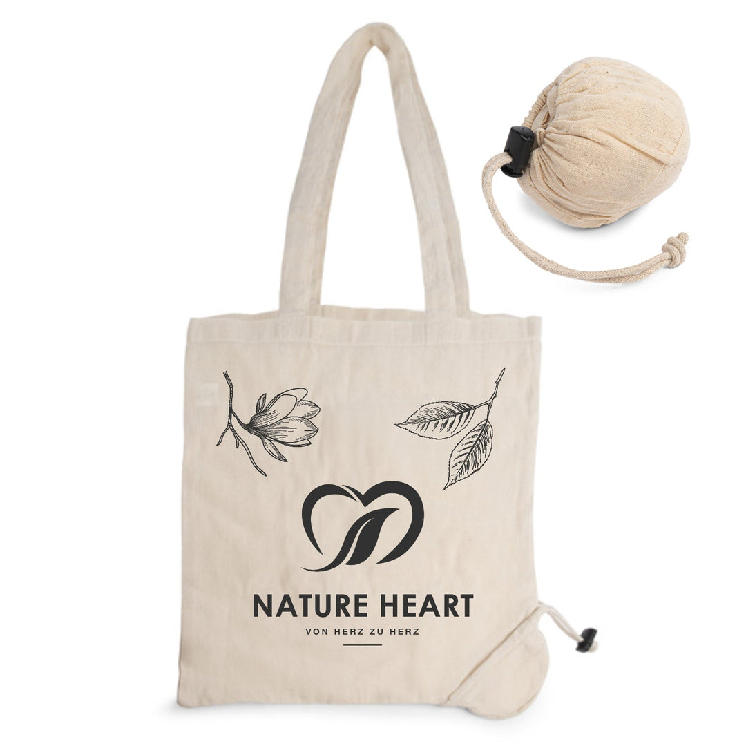Nature Heart Baumwolltasche Heart in Natur mit Logo und Blütenmotiv, daneben eingerollt als kleiner Beutel mit Kordelzug