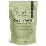 Ein hellgrüner Standbodenbeutel mit Nature Heart Creamy Protein Pulver, Geschmacksrichtung Green Pistachio, 450g Inhalt. Die freigestellte Verpackung ist mit Illustrationen von Pistazien verziert.