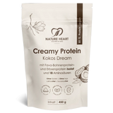 Ein cremeweißer Standbodenbeutel mit Nature Heart Creamy Protein Pulver, Geschmacksrichtung Kokos Dream, 450g Inhalt. Die freigestellte Verpackung zeigt Illustrationen von Kokosnüssen und einer Magnolienblüte.