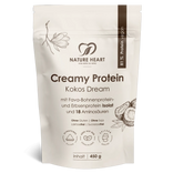 Ein cremeweißer Standbodenbeutel mit Nature Heart Creamy Protein Pulver, Geschmacksrichtung Kokos Dream, 450g Inhalt. Die freigestellte Verpackung zeigt Illustrationen von Kokosnüssen und einer Magnolienblüte.