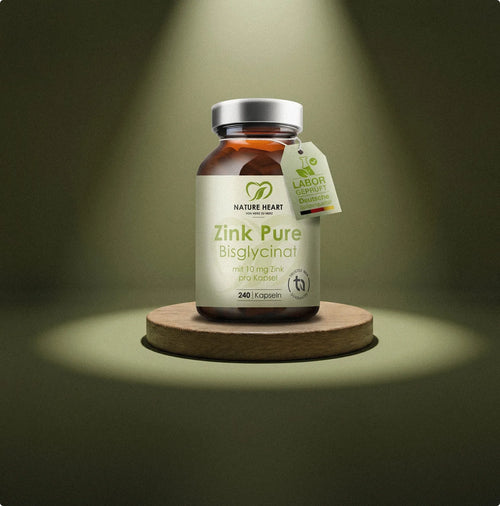 Ein Braunglas Nature Heart Zink Pure Bisglycinat Kapseln steht im Fokus eines Scheinwerferlichts auf einem runden Holzsockel.