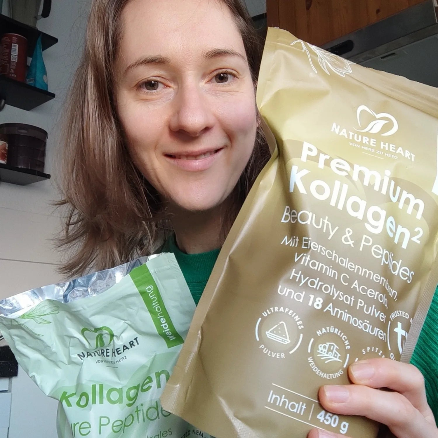 Eine Frau präsentiert zwei verschiedene Packungen von Nature Heart: Kollagen Pure Peptides und Premium Kollagen² Beauty & Peptides.