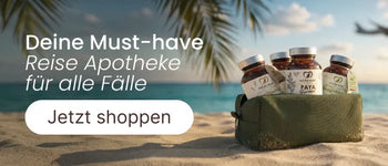 Kulturtasche mit Nature Heart Nahrungsergänzungsmitteln wie Paya Formel und Magnesium an einem tropischen Sandstrand vor blauem Meer mit der Aufschrift Deine Must-have Reiseapotheke für alle Fälle.