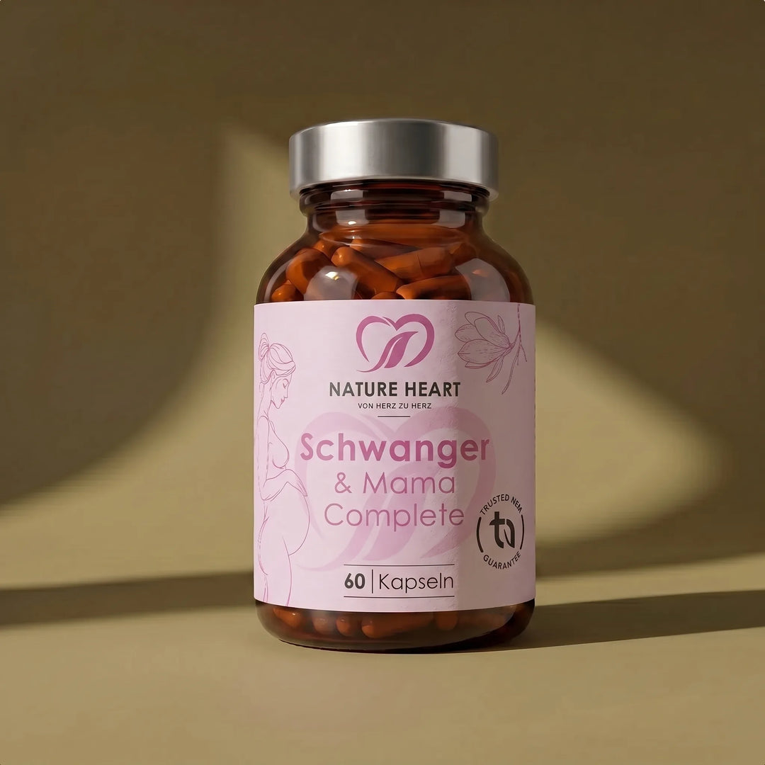 Ein braunes Glas mit silbernem Deckel von Nature Heart mit dem Nahrungsergänzungsmittel „Schwanger & Mama Complete“. Das rosa Etikett zeigt die Silhouette einer schwangeren Frau, florale Elemente und den Hinweis auf 60 Kapseln.