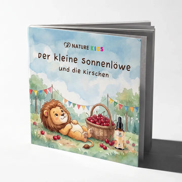 Nature Kids Kinderbuch „Der kleine Sonnenlöwe und die Kirschen“: Cover mit Löwe neben einem Korb voller Kirschen